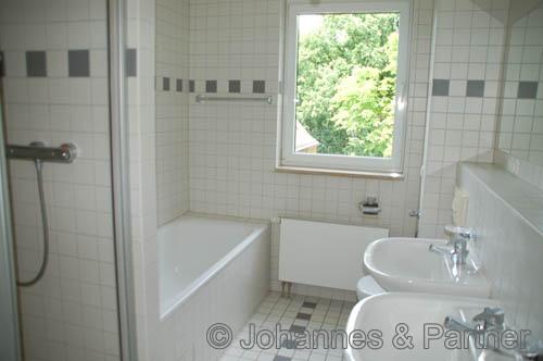 Bad mit Badewanne, Dusche, Fenster und Doppelwaschbecken