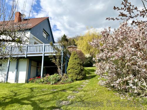 seitliche Hausansicht aus dem Garten mit Blick auf den großen Balkon