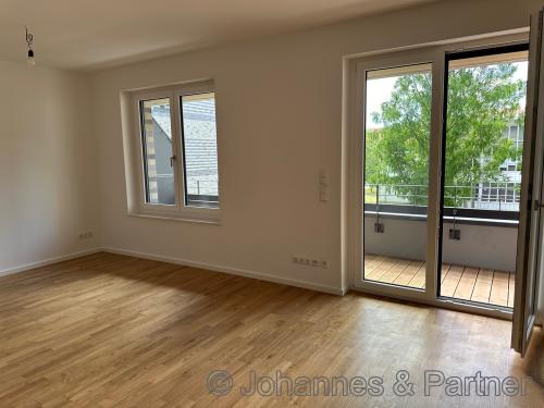 großes, helles Wohnzimmer mit offener Küche und Zugang zum Balkon