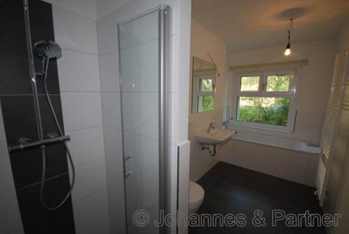 großes Bad mit Badewanne und Dusche und Fenster  