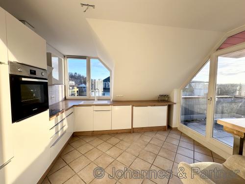 helle Küche mit Einbauküche und Zugang zur Dachterrasse